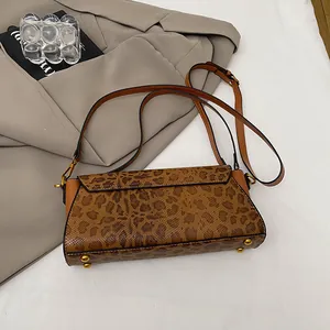 Vista dettagliata della base della borsa leopardata con piedini protettivi in metallo oro