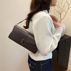 Dettaglio borsa baguette vintage marrone con stampa serpente e fibbia in metallo dorato
