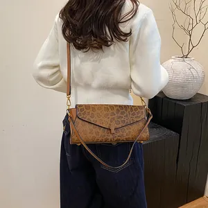 Borsa a tracolla chic con stampa leopardata indossata dalla modella con patta e chiusura