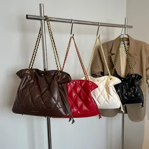 Detailed close-up of four quilted leather bucket bags with metal chain straps in various colors