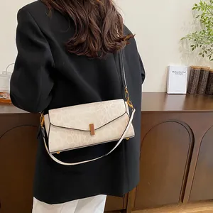 Dettaglio della trama a serpente beige con chiusura girevole in legno sulla borsa
