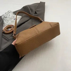 Détail du sac porté épaule marron grainé avec ferrures argentées et bandoulière amovible