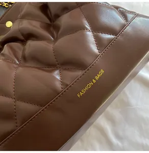 Close-up of dark brown quilted leather bucket bag with gold Fashion & Bags lettering