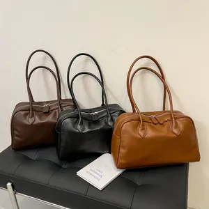 Three colors of vintage textured leather tote bags displayed on a black leather bench
