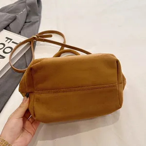 Detailed bottom view of brown suede tote bag featuring reinforced stitching and slender strap