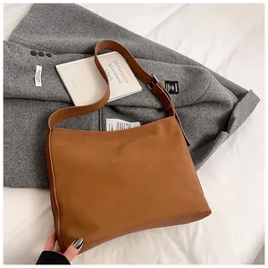 Detail of vintage brown tote bag texture on grey suit with natural lighting setup