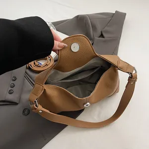 Vue de dessus sac baguette en cuir grainé marron avec poche zippée et fermoir magnétique