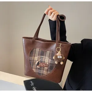 Detailaufnahme der braunen Shopper-Tasche mit Hunde-Stickerei und Herz-Aufnäher