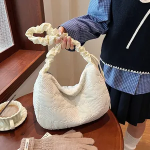 Detail of cream quilted crescent bag with chessboard pattern and scrunchie strap design