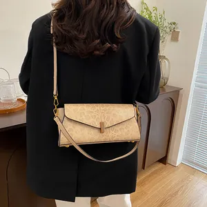 Dettaglio della borsa baguette beige con motivo animale e fibbia rettangolare in metallo dorato