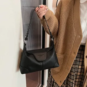 Détail du cuir grainé noir et des ferrures argentées sur ce sac à bandoulière