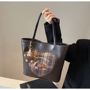Details einer Vintage braunen Tragetasche mit Herzmuster und Dackel-Stickerei