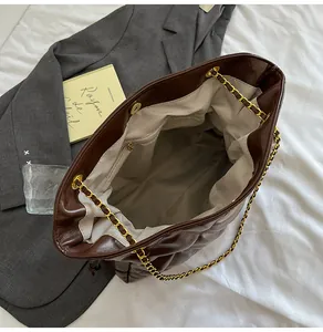 Detailed interior of dark brown quilted leather tote bag with chain strap and lining