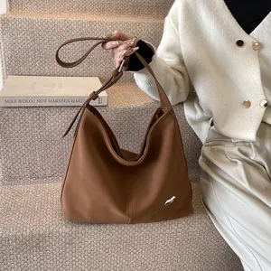 Brown matte leather hobo bag featuring silver hardware and adjustable strap on steps