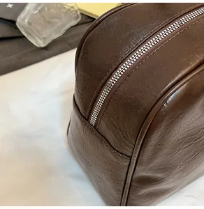 Detail of dark brown lychee texture faux leather with premium metal zipper closure