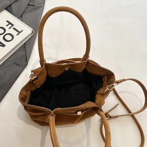 Top view of spacious brown suede tote bag with black lining and detachable strap