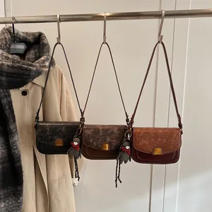 Drei Retro-Umhängetaschen in Schwarz, Dunkelkaffee und Rotbraun mit Bärenanhänger-Detail