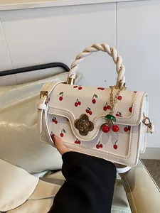Borsa a mano color crema con stampa ciliegia, manico intrecciato e chiusura a fiore