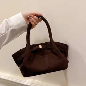 Close-up of a vintage dark brown suede tote bag with a metallic square buckle detail