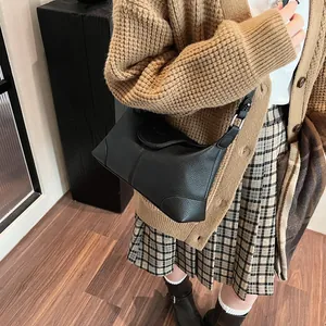 Vue détaillée du sac à bandoulière en cuir grainé noir avec boucle argentée élégante