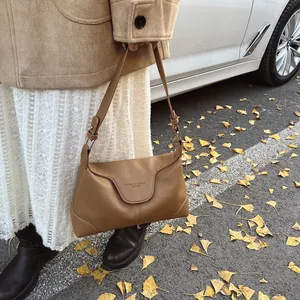 Détail du sac à bandoulière en cuir grainé marron caramel avec texte mode embossé
