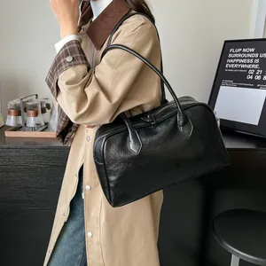 Close-up of black retro tote bag in soft leather with silver zippers and handles