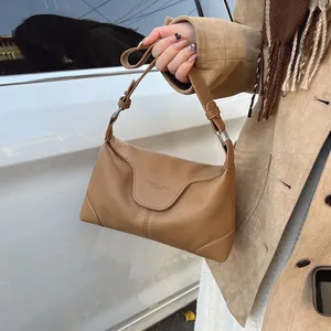 Détail de la texture en cuir litchi marron caramel sur un sac à bandoulière vintage