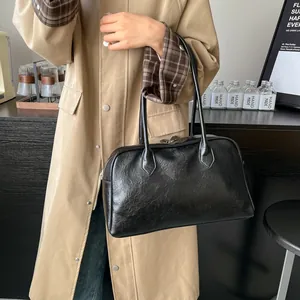 Detail of a black vintage bowling tote bag worn with a classic khaki trench coat