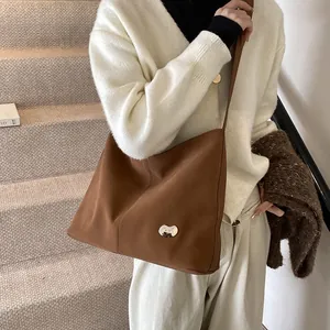 Detail of vintage brown tote bag showing matte texture and silver bean-shaped buckle