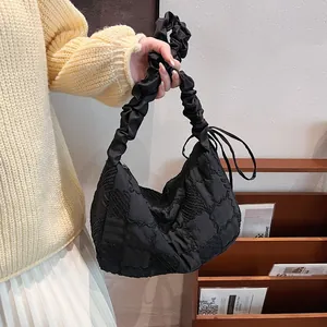 Macro shot of black quilted cloud bag with ruched handle and chessboard texture