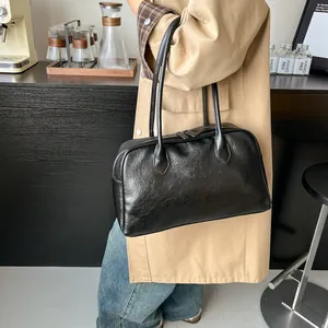 Retro black matte leather tote bag with long handles shown in a lifestyle cafe setting