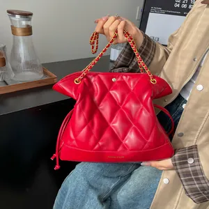 Detail of red quilted leather bucket bag with gold chain strap and drawstring closure