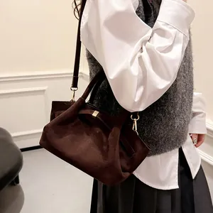 Detail shot of vintage dark brown suede tote bag featuring elegant golden metal hardware