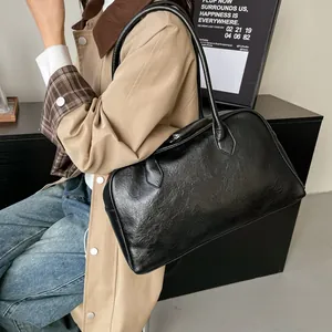 Model wearing a large black leather tote bag with a vintage oily finish for women