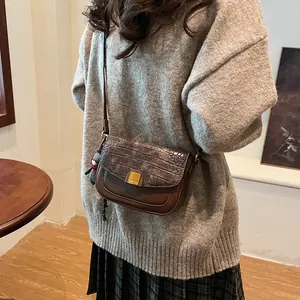Detailaufnahme der braunen Vintage-Tasche mit Kroko-Textur und goldener PANTOR-Schnalle