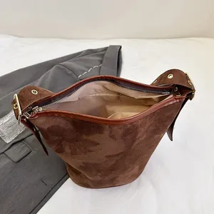 Macro view of brown suede bucket bag interior with light lining and zipper pocket