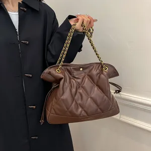 Detail of quilted brown tote bag showing premium PU leather texture and gold chain strap