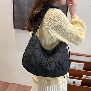 Black quilted tote bag with pleated ruffled straps and textured fabric shown on model
