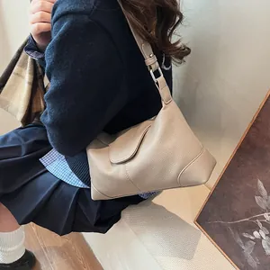 Gros plan détaillé du cuir grainé abricot et de la texture de ce sac à bandoulière rétro