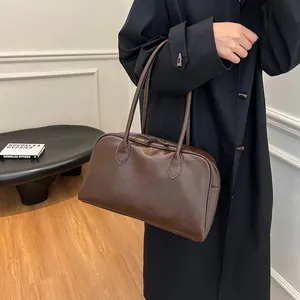 Close-up of premium brown vintage tote bag showing textured leather and zipper detail
