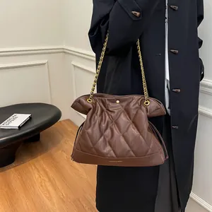 Close-up of a brown quilted chain shoulder bag with a metallic finish and logo detail