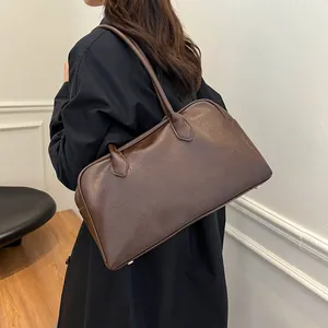 Detail of dark brown tote bag showing durable silver metal feet and smooth faux leather