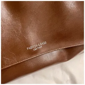 Detail of high-quality brown leather texture with silver Fashion & Bags text on tote