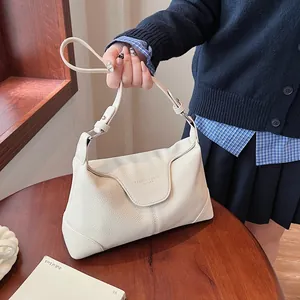 Détail du sac à bandoulière en cuir grainé blanc crème avec rabat et sangle réglable
