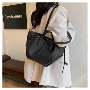 Détail du sac cabas noir en cuir grainé avec d'élégantes surpiqûres contrastées blanches