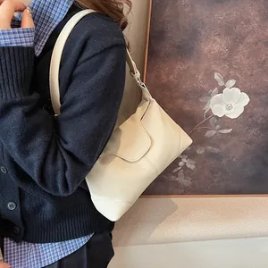 Détail d'un sac d'épaule blanc crème en cuir grainé avec une large bandoulière