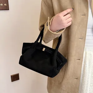 Detail of black suede tote bag with golden metal buckle and retro minimalist texture