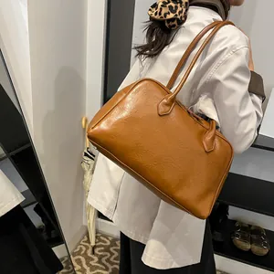 Brown retro tote bag worn by a model in a minimal interior, showing spacious shoulder fit