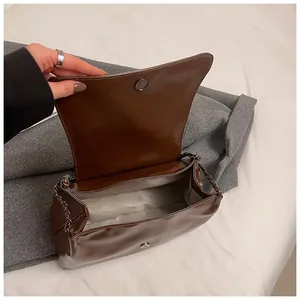 Close-up of brown patent leather shoulder bag with chain strap and spacious interior