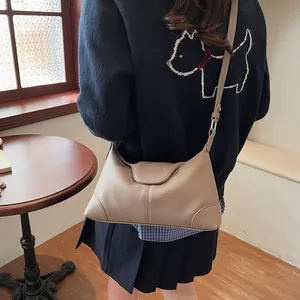 Vue détaillée du sac beige en cuir grainé avec embossage et bandoulière réglable